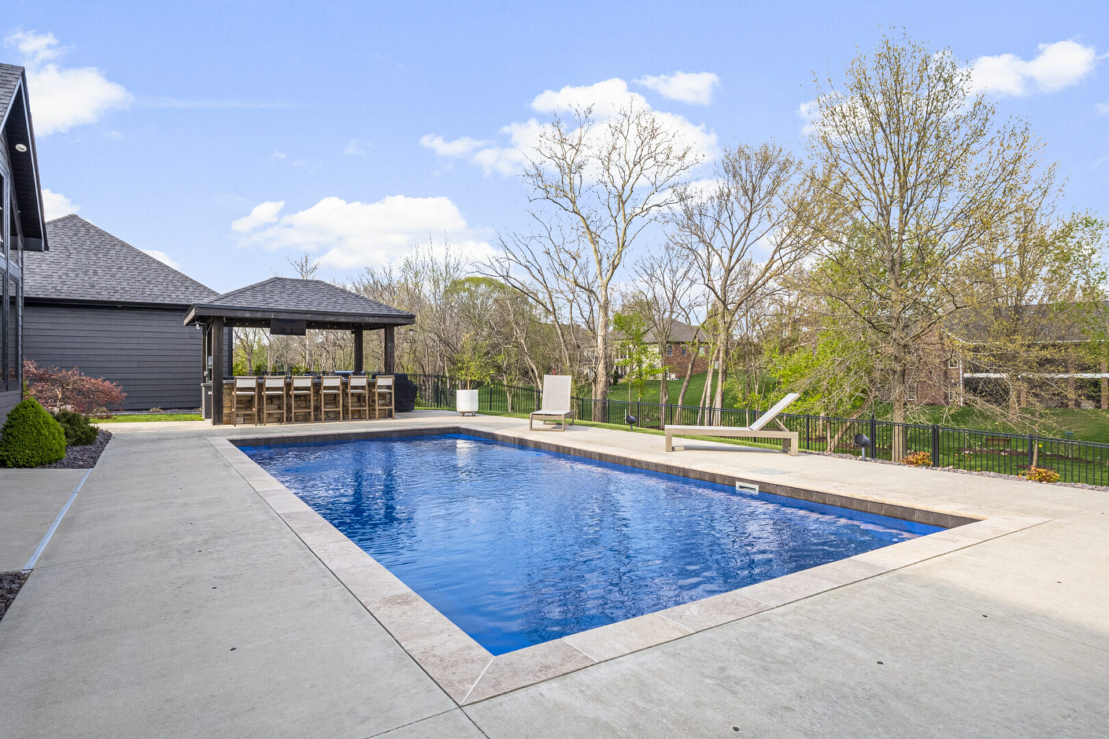 drone pool A contemporary mountain-style home features a stone and brick exterior. Over the front entrance, dark wooden beams stretch out, adding a touch of grandeur.
