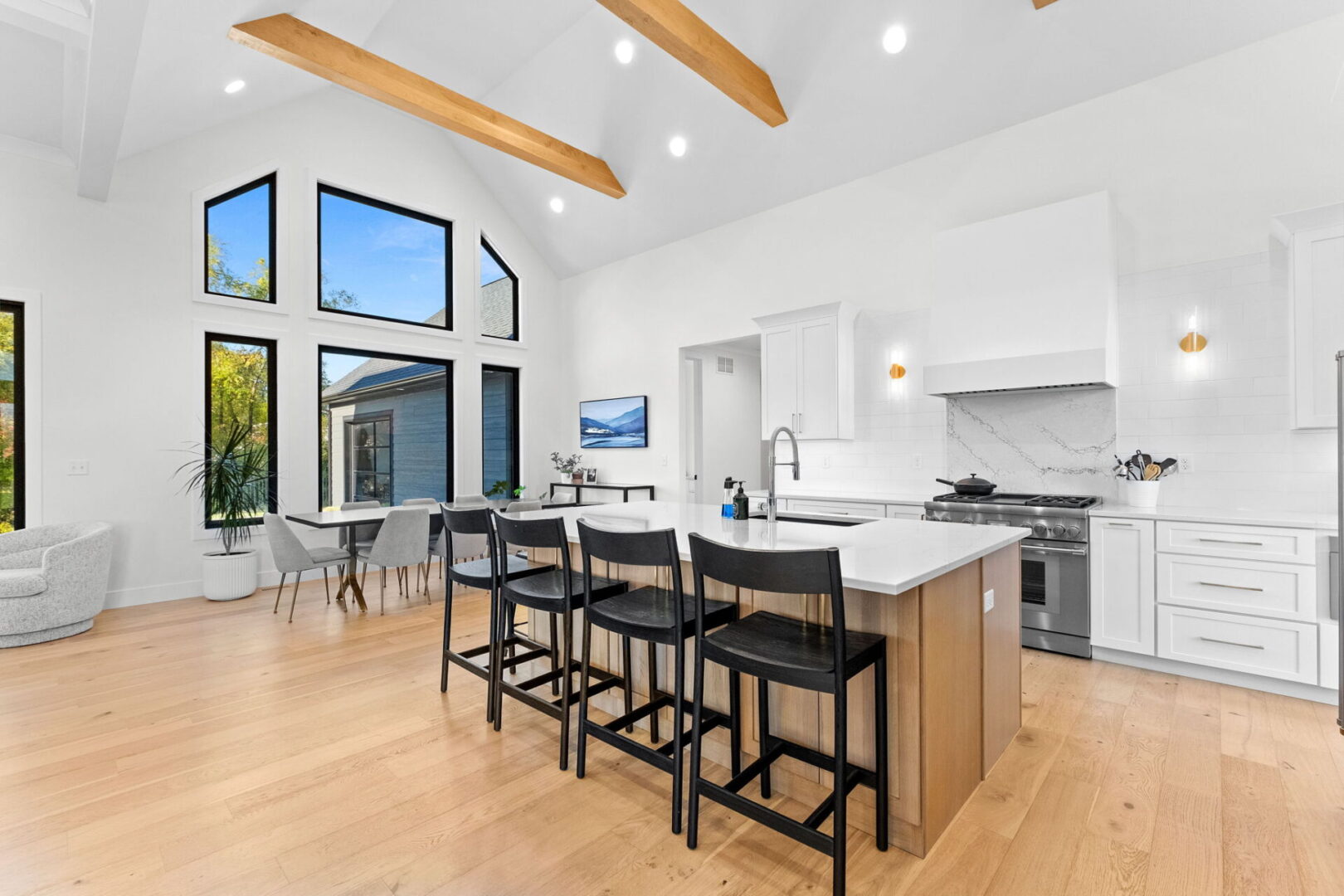 A modern kitchen featuring Cambria countertops and backsplash, complemented by Shiloh cabinets and open shelving.