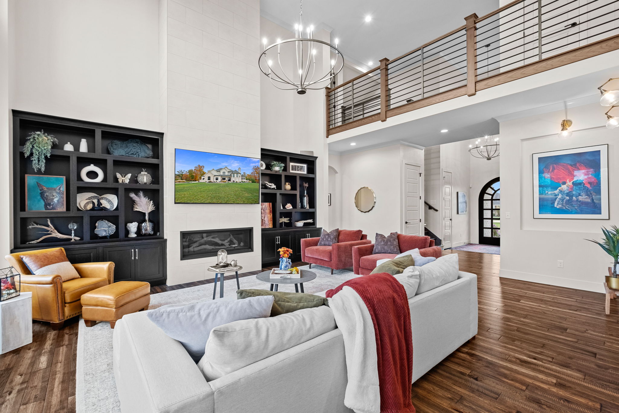 A great room featuring a tiled fireplace, 14-foot ceilings, and a two-story design.