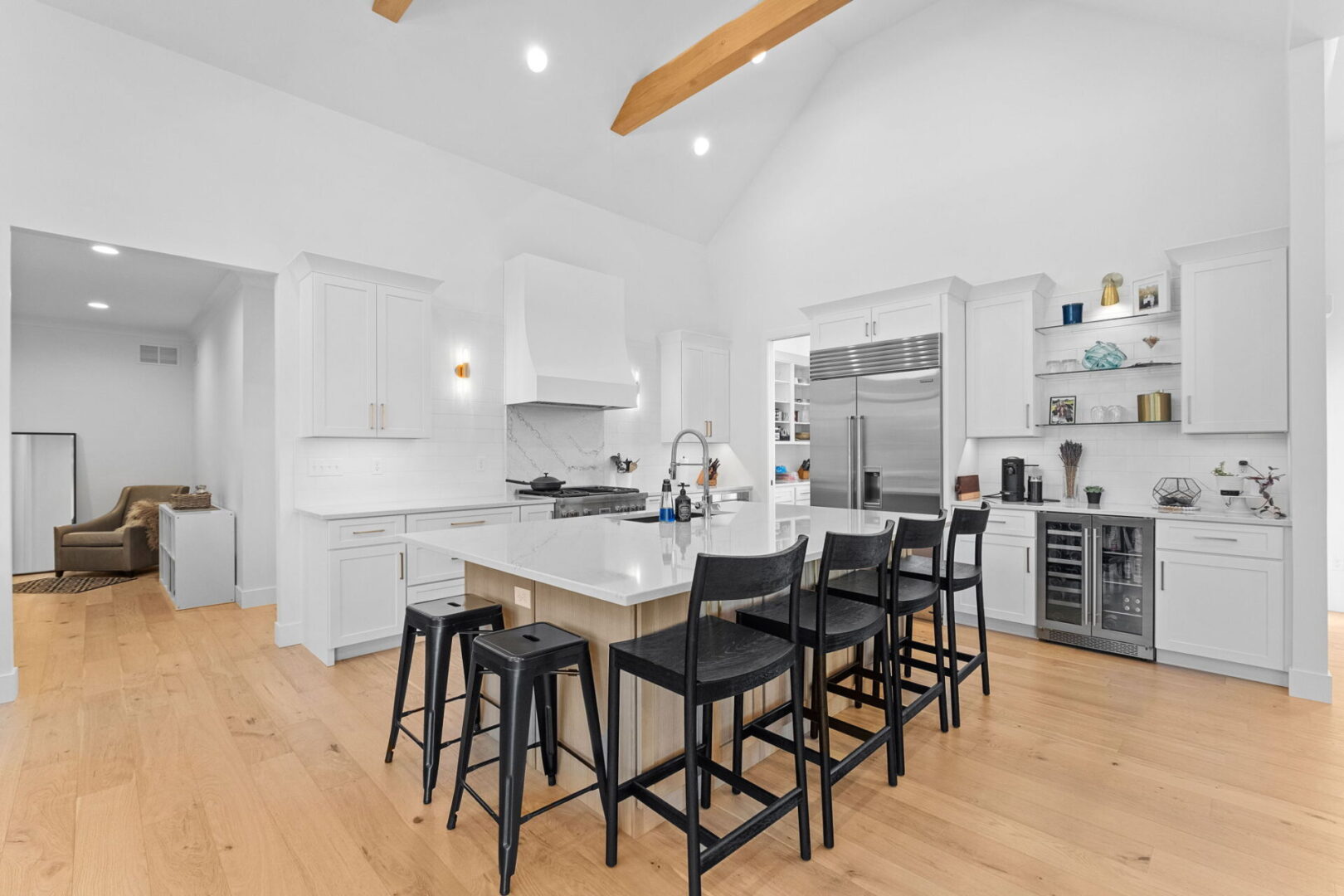 A modern kitchen featuring Cambria countertops and backsplash, complemented by Shiloh cabinets and open shelving.