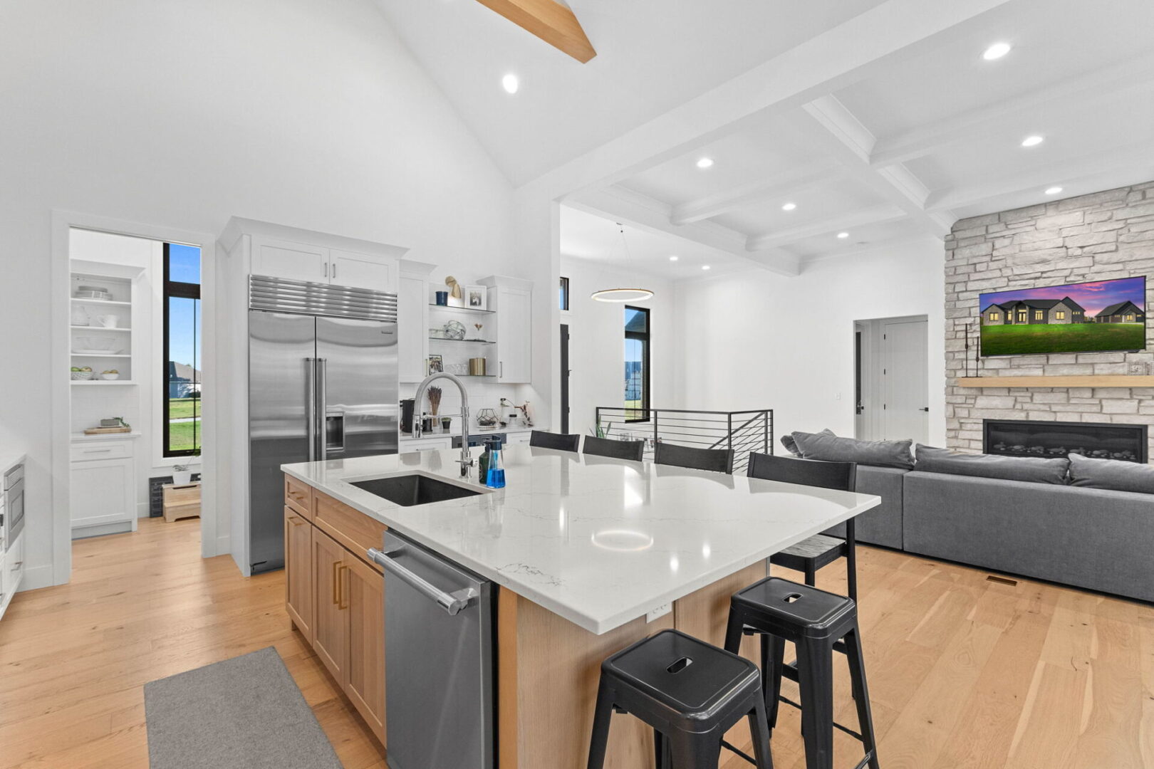 A modern kitchen featuring Cambria countertops and backsplash, complemented by Shiloh cabinets and open shelving.