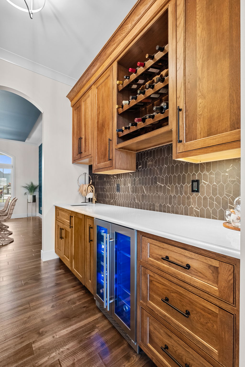 The butler's pantry includes wine racking and a mini fridge, with direct access to the formal dining room from both the sitting room and kitchen.