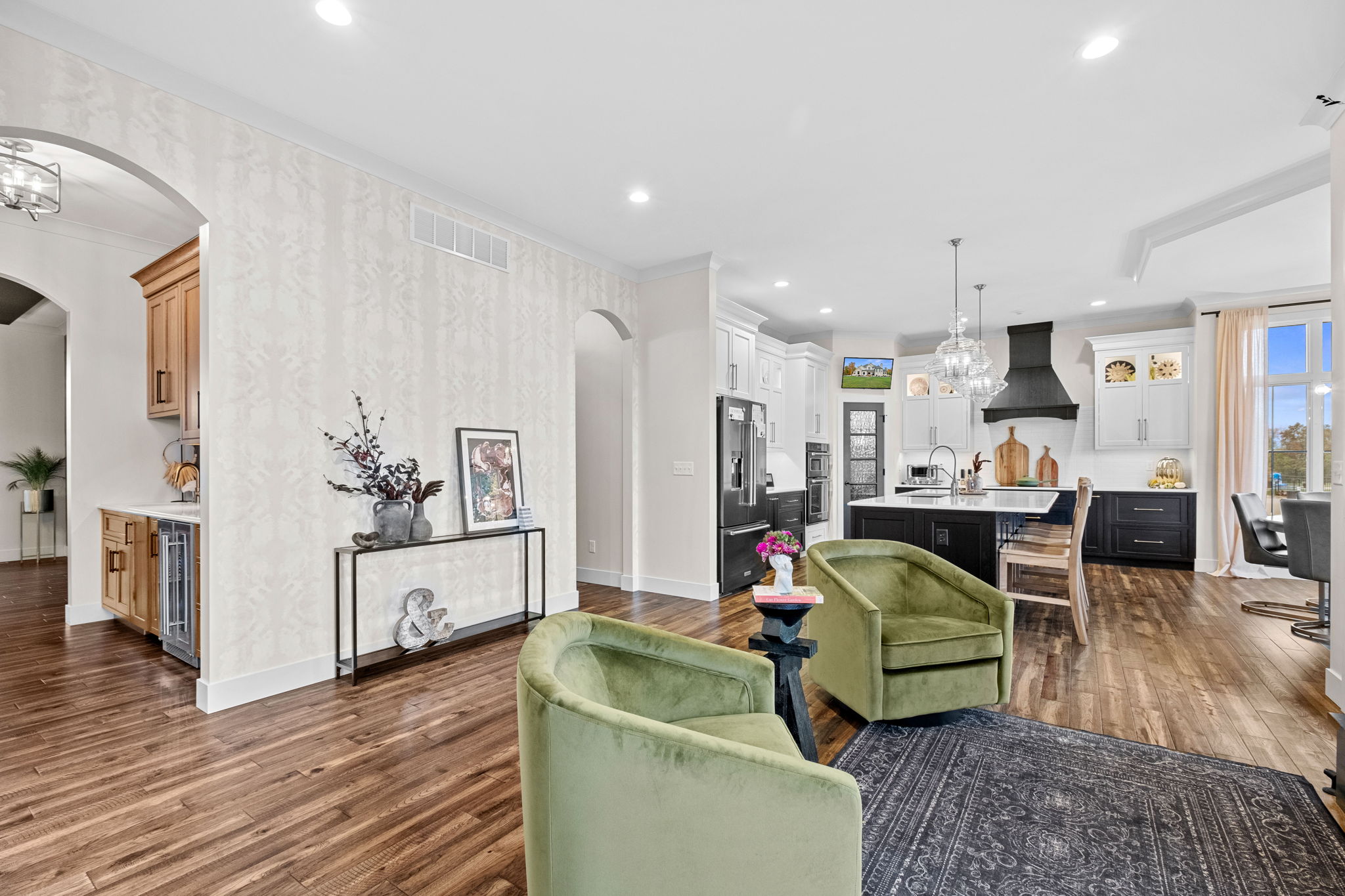 Sitting room right off the modern kitchen featuring a large bay window, a drop ceiling, a spacious island with Cambria quartz countertops, and custom Shiloh cabinets. A bay window complements the dining room, enhanced by an elegant drop ceiling.