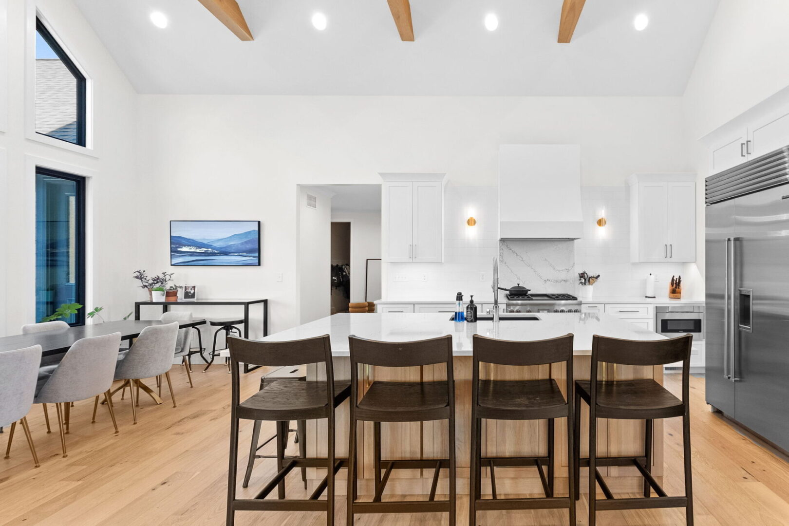 A modern kitchen featuring Cambria countertops and backsplash, complemented by Shiloh cabinets and open shelving.