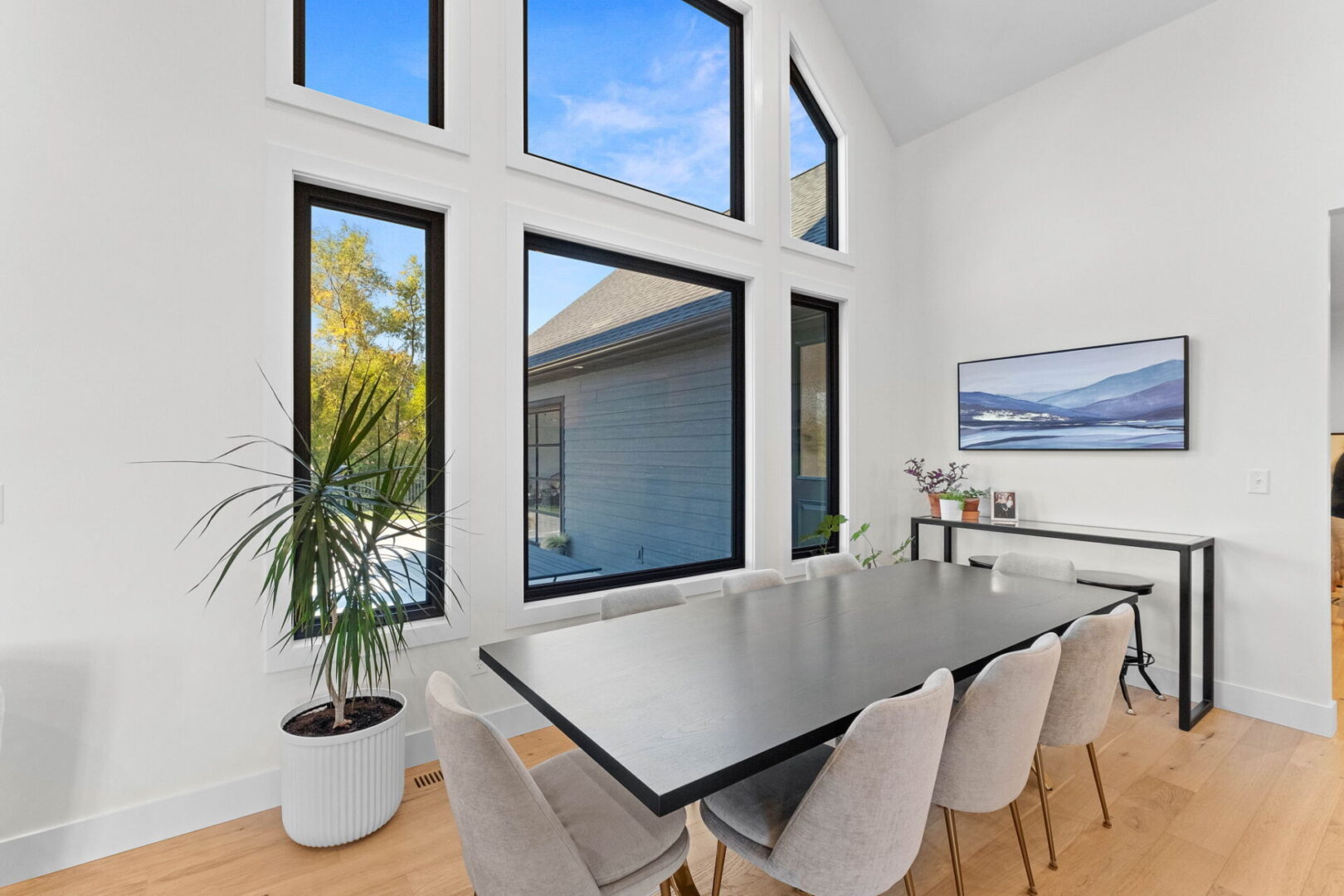 Large dining room featuring an expansive wall of windows, offering a modern twist.