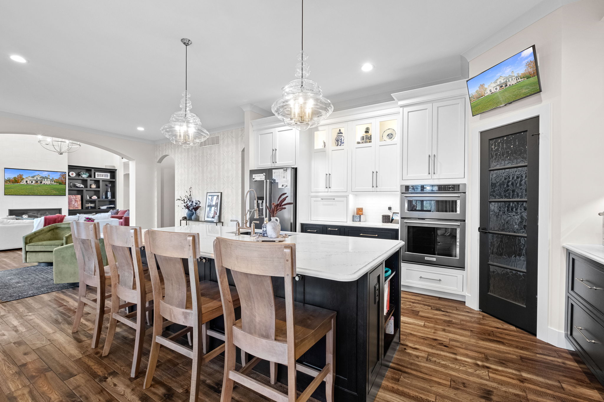 A modern kitchen featuring a large bay window, a drop ceiling, a spacious island with Cambria quartz countertops, and custom Shiloh cabinets.