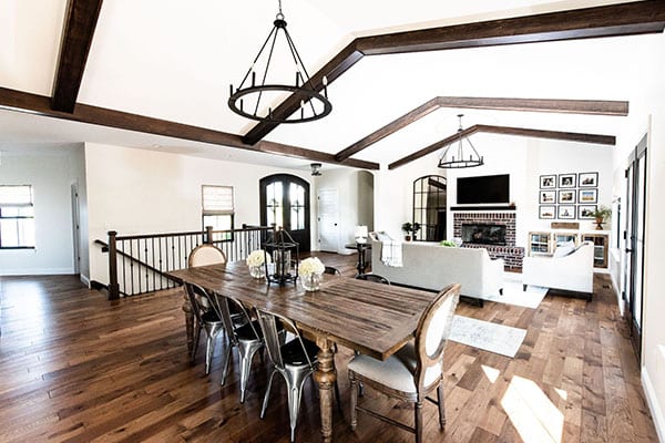 An elegant, modern farmhouse with an open floor plan features a kitchen that seamlessly transitions into the dining room and great room. pioneer ridge