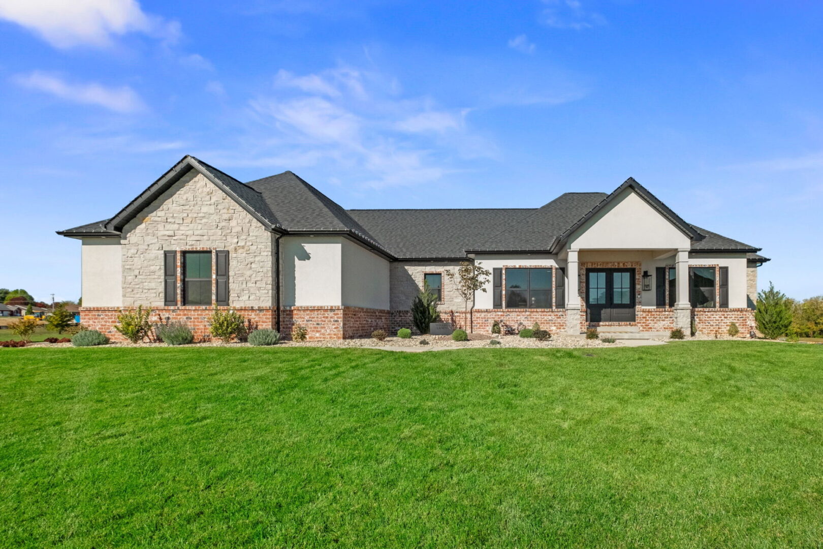 A front elevation featuring red brick, cream stone, and a prominent front entry.