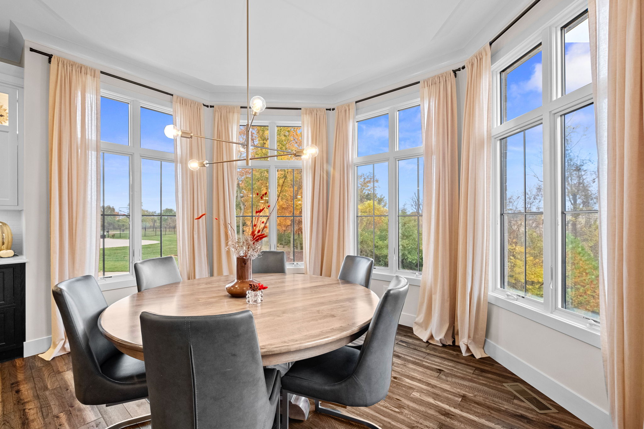 A bay window complements the dining room, enhanced by an elegant drop ceiling.