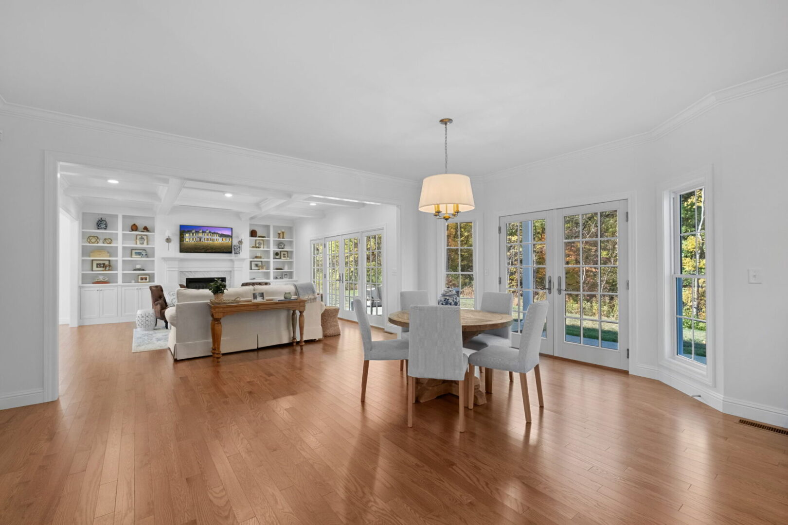 A luxurious, traditional colonial-style kitchen with an eat-in area and a modern open floor plan that extends through the kitchen into the great room.