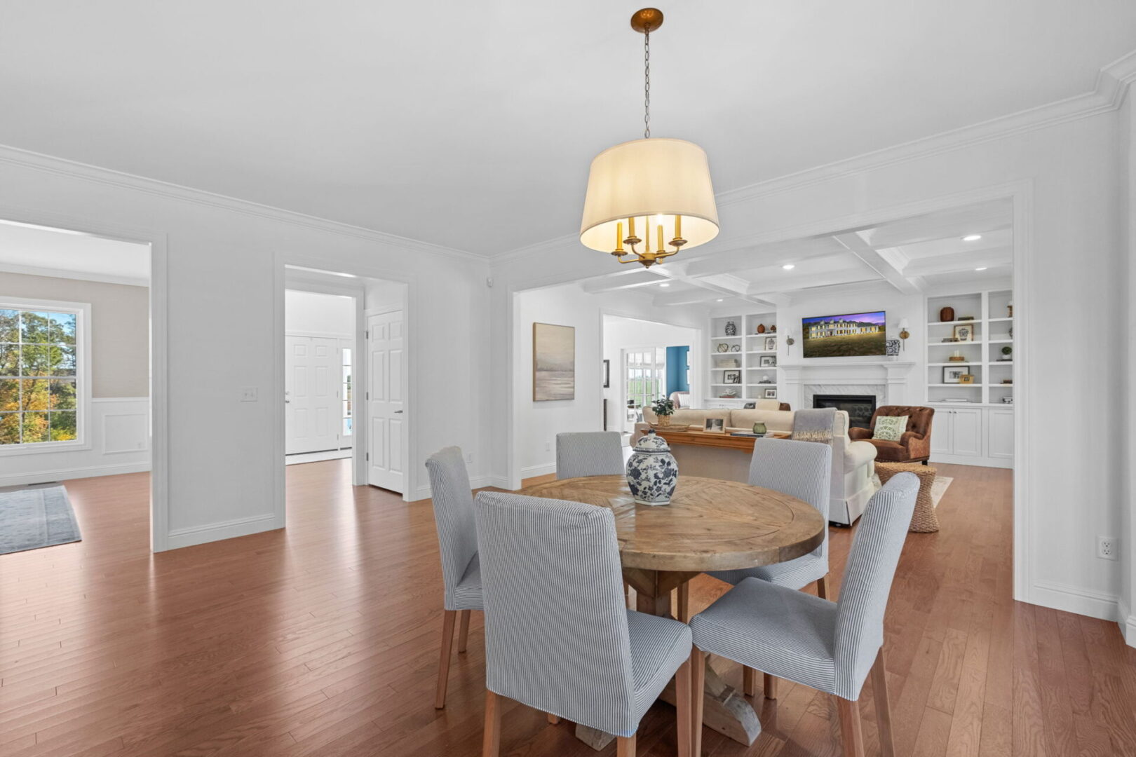 A luxurious, traditional colonial-style kitchen with an eat-in area and a modern open floor plan that extends through the kitchen into the great room.