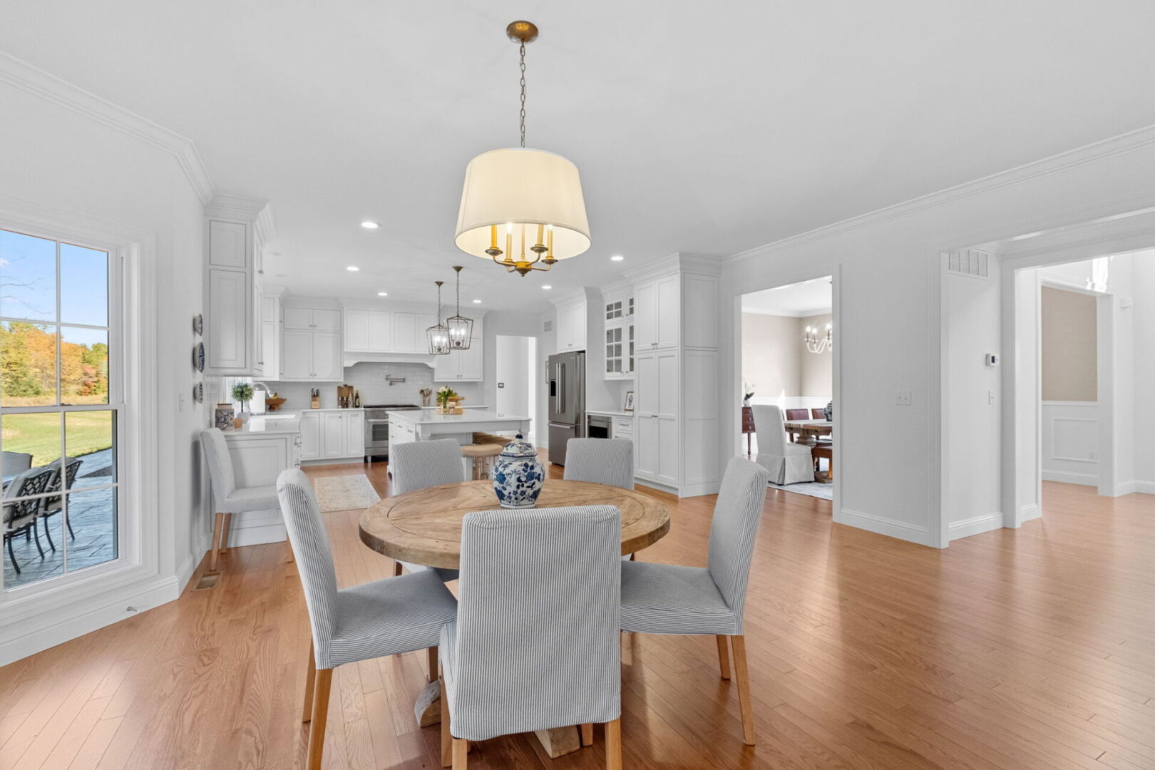 A luxurious, traditional colonial-style kitchen with an eat-in area and a modern open floor plan that extends through the kitchen into the great room.