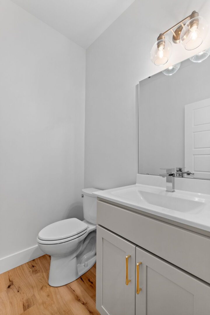 Custom cabinets for a half bathroom featuring modern golden accents.