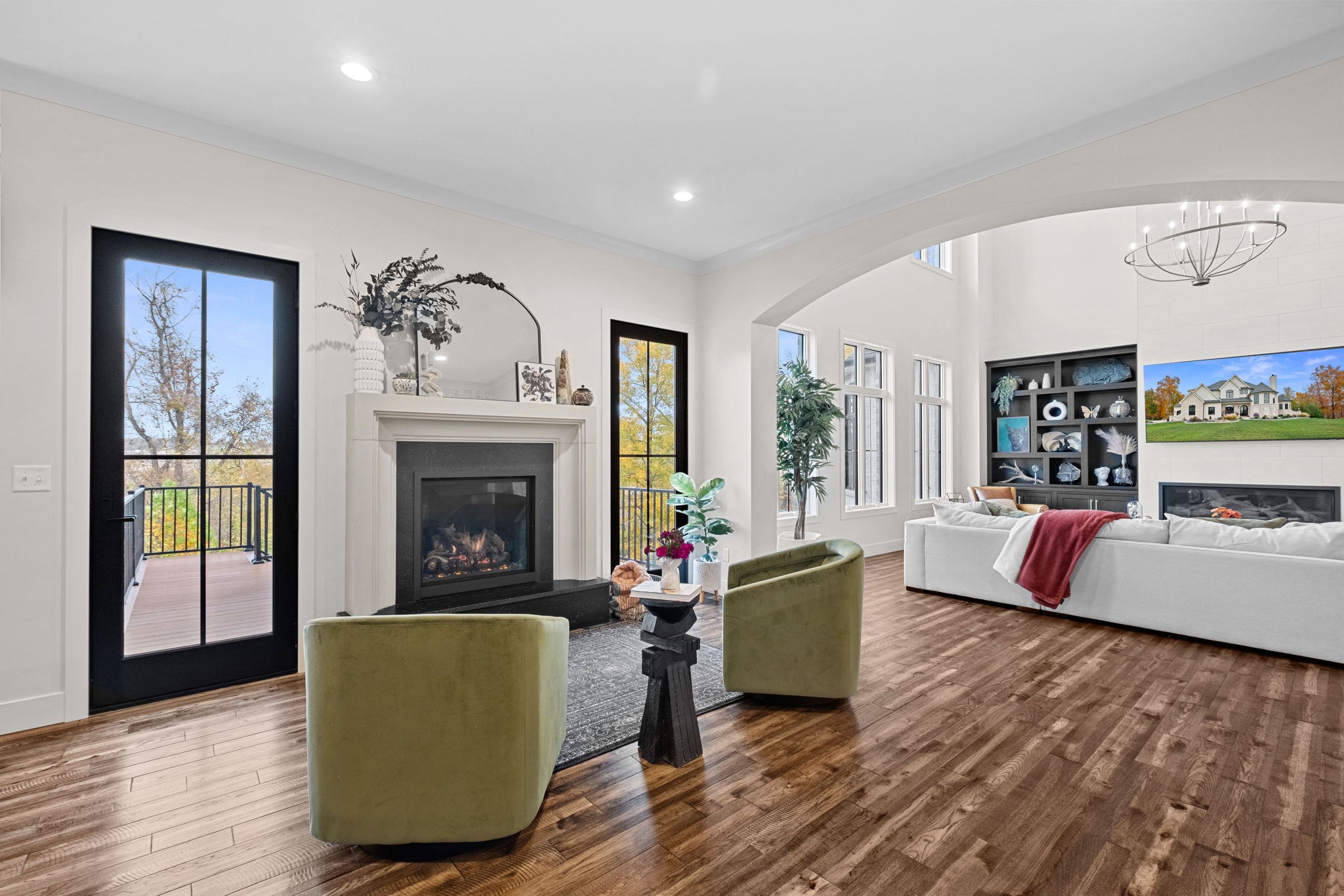 A sitting room adorned with custom wallpaper, featuring arched entryways and direct access to the butler's pantry and dining room.