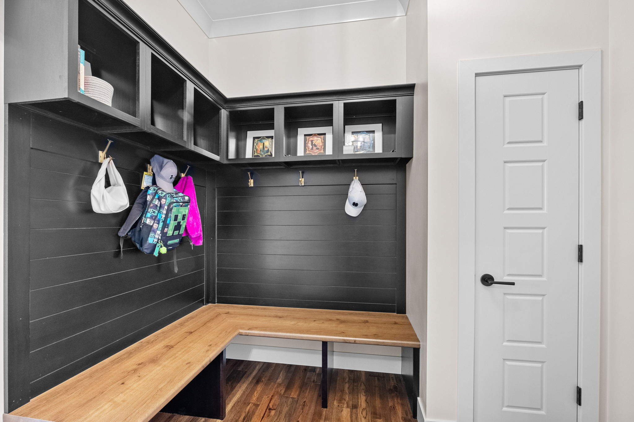 A modern drop zone entry from the garage featuring a shiplap design and modern cubbies.