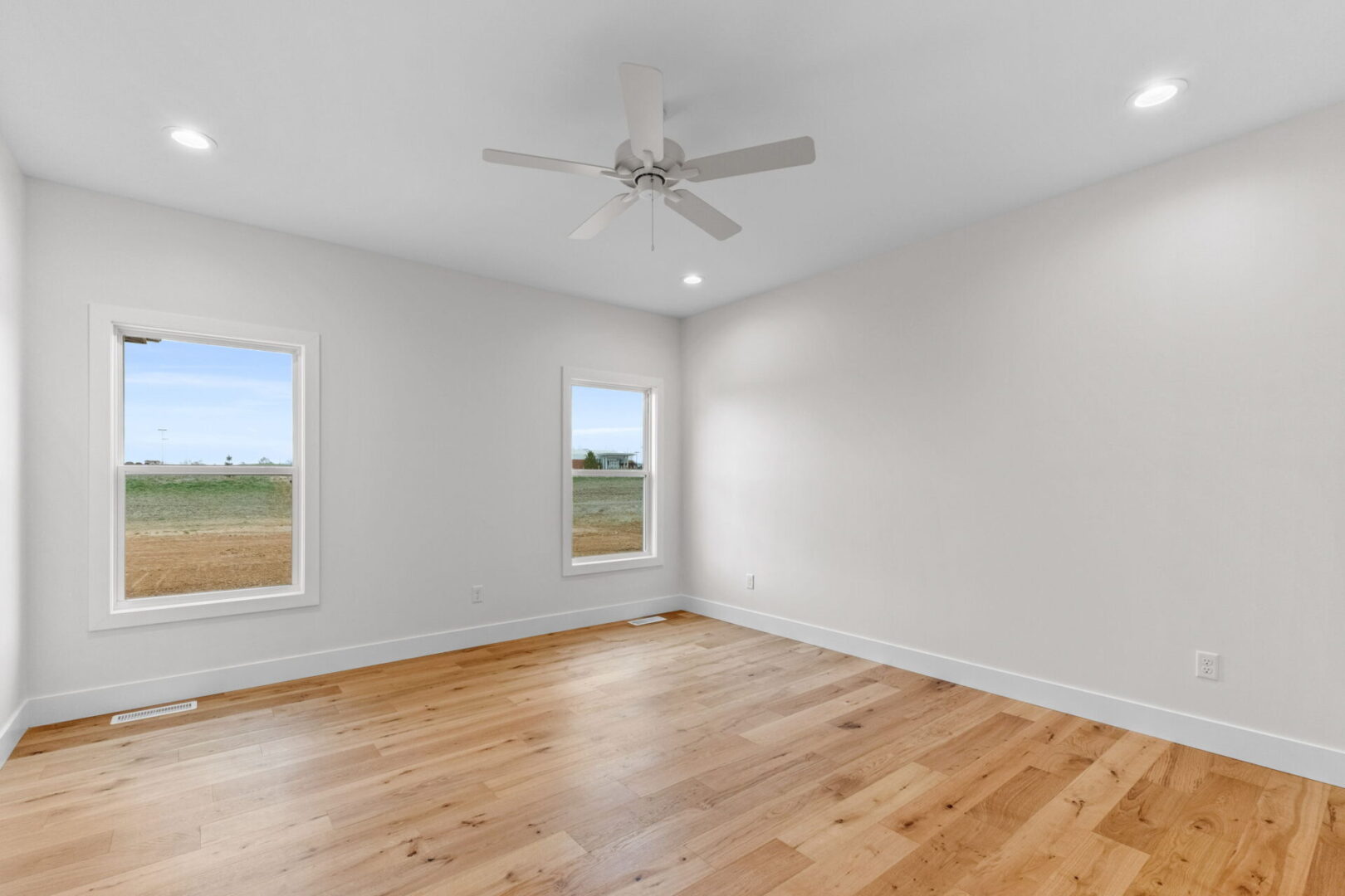 Primary bedroom with engineered hardwood floors.