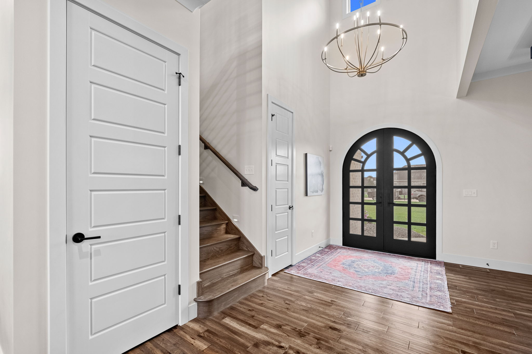 Front entry featuring a custom-designed arched wooden door.