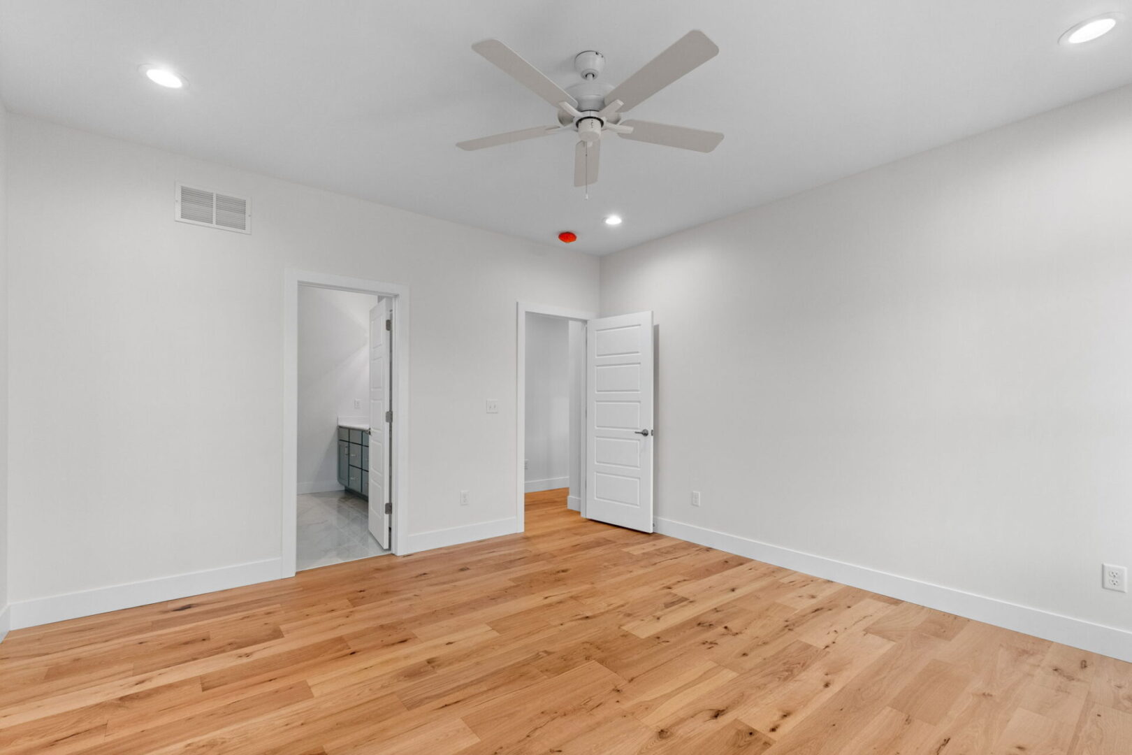 Primary bedroom with engineered hardwood floors.
