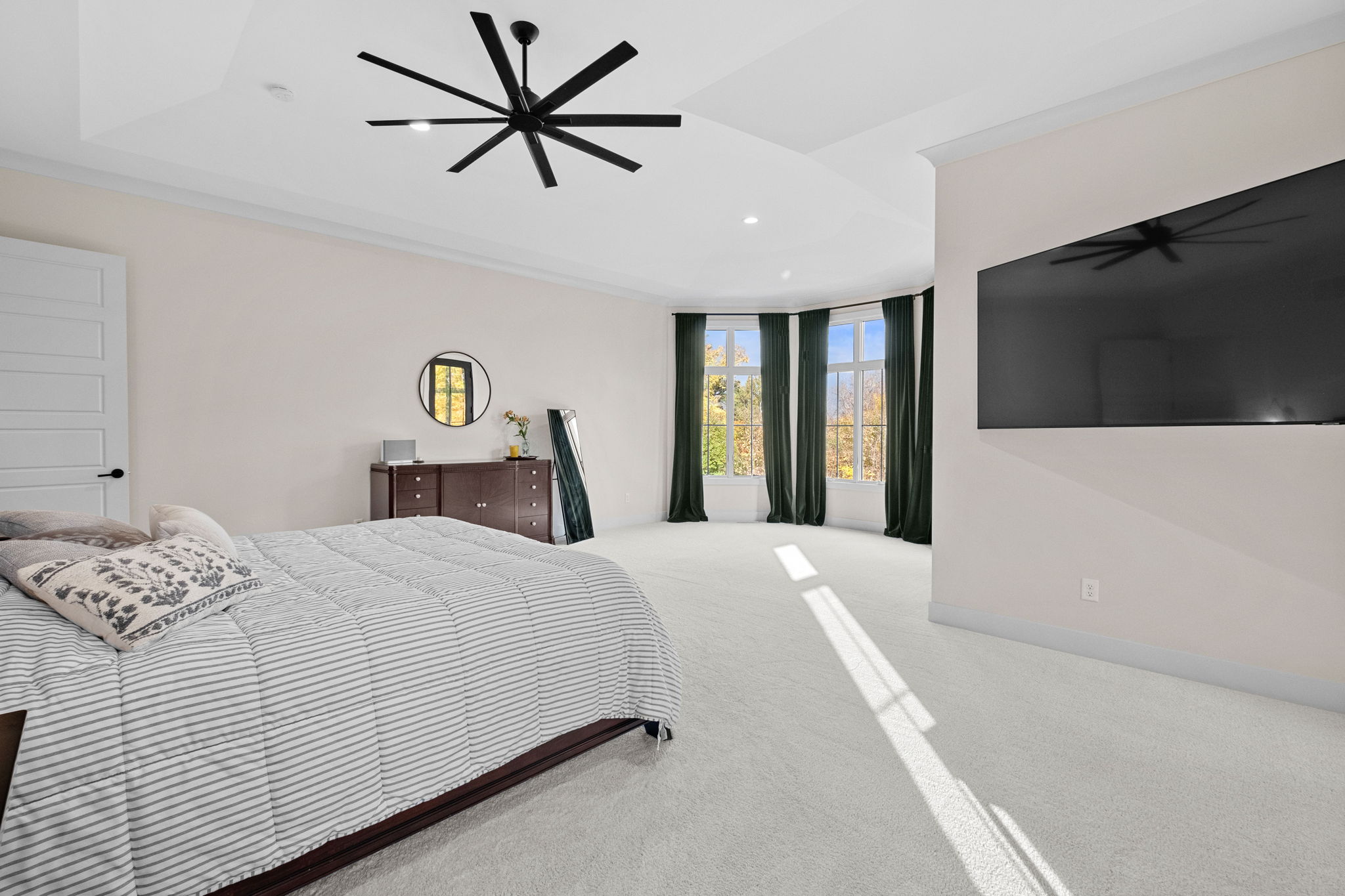 The primary suite boasts ceilings over 10 feet high and a spacious bay window.