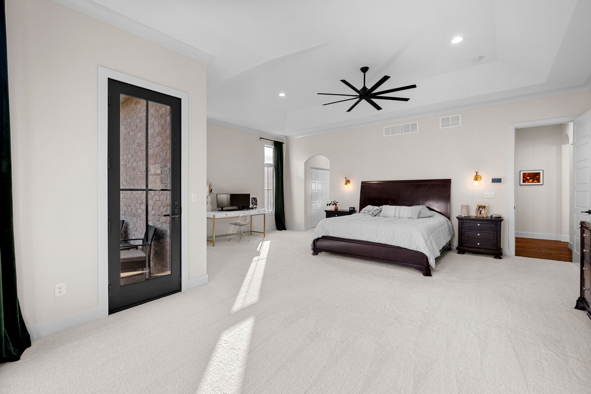 A primary suite featuring soaring ceilings over 10 feet high and a secluded balcony.