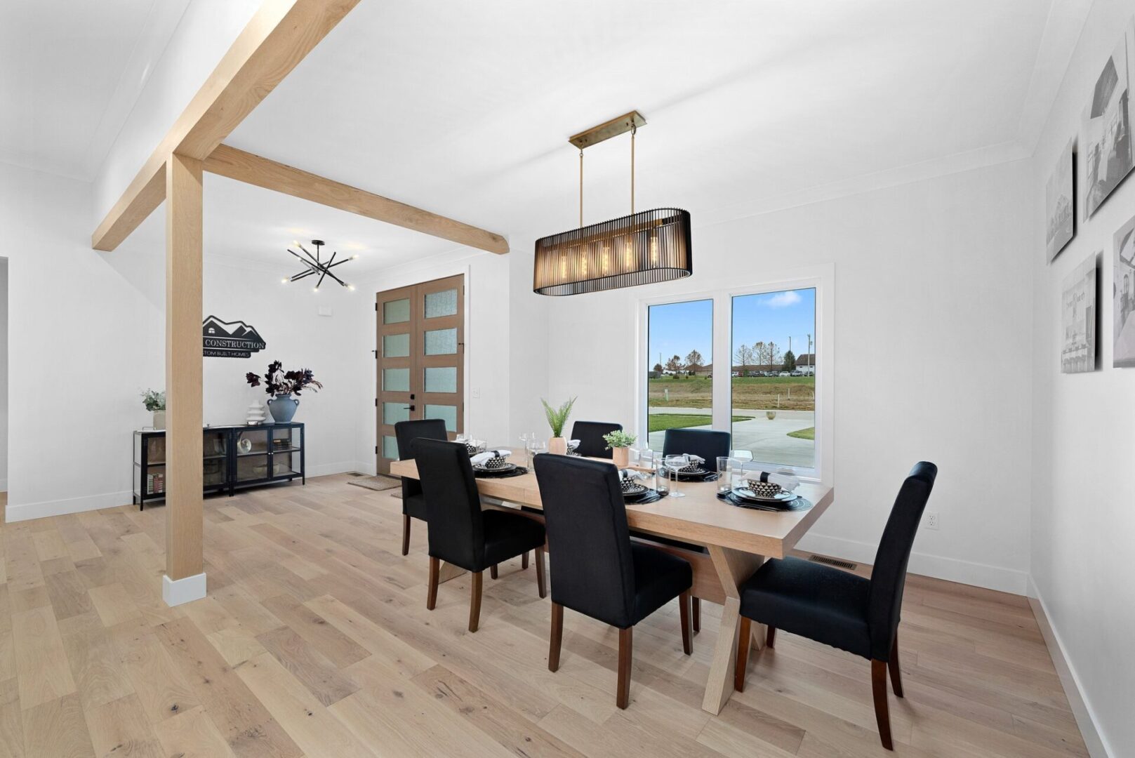 Dine in a room adorned with modern lighting, white oak beams, and engineered hardwood floors.