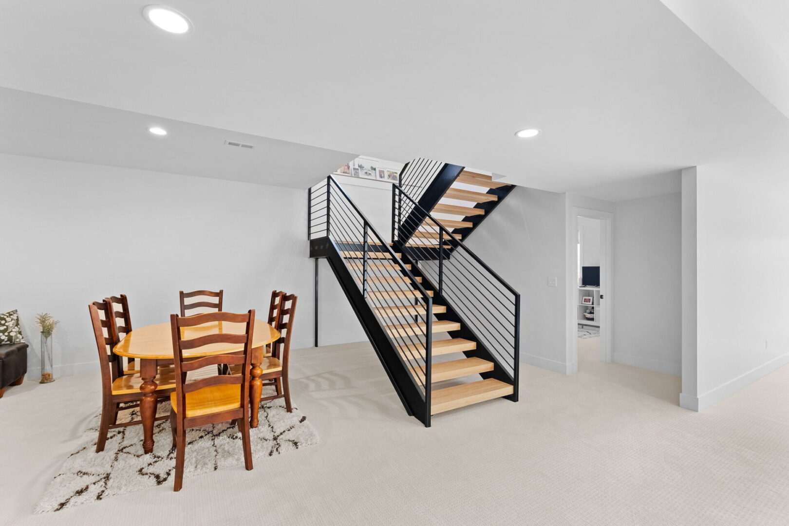 Basement entertaining family room with iron staircase.