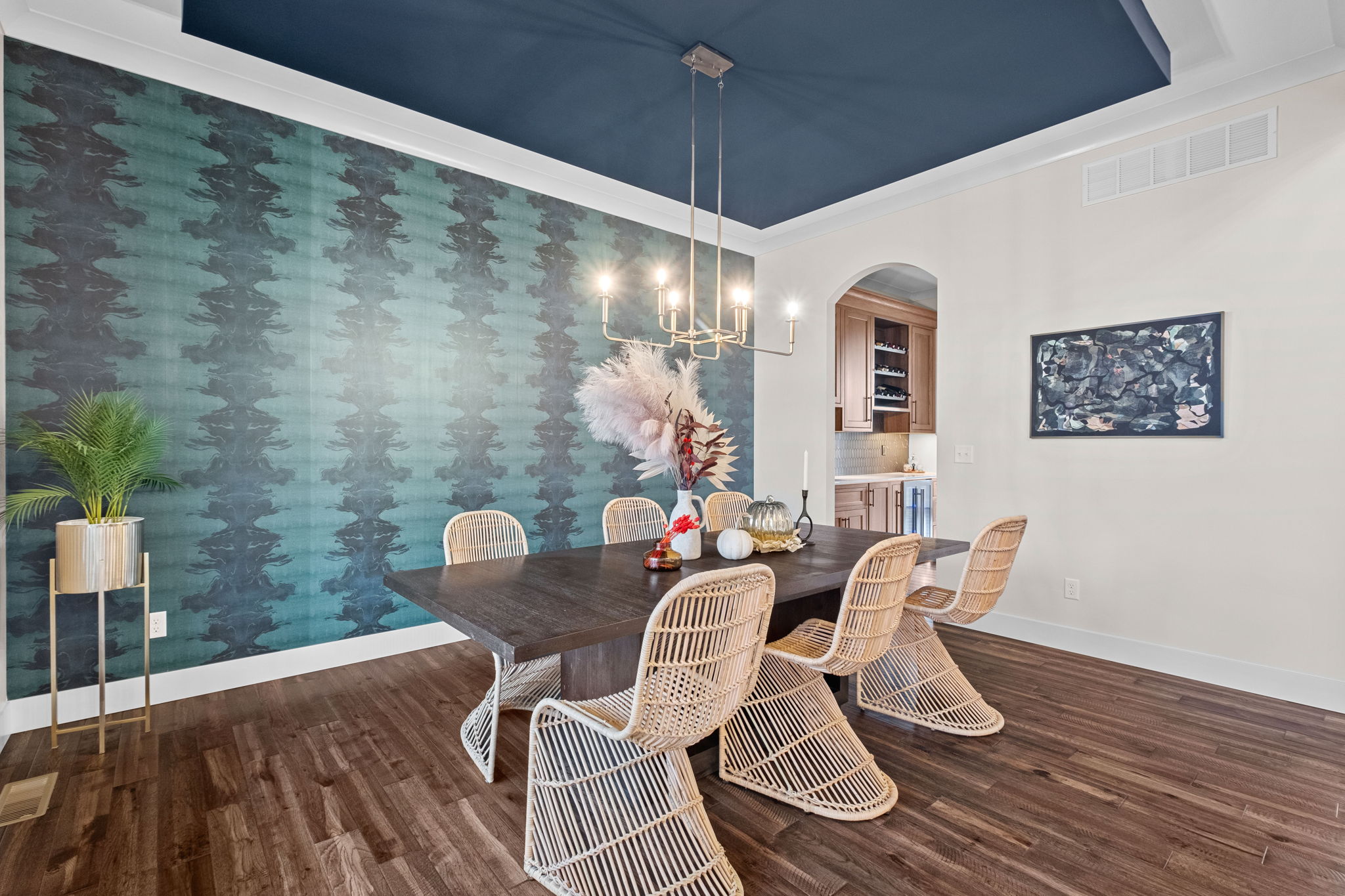A formal dining room adorned with a drop ceiling and wallpaper custom-designed by the homeowner.