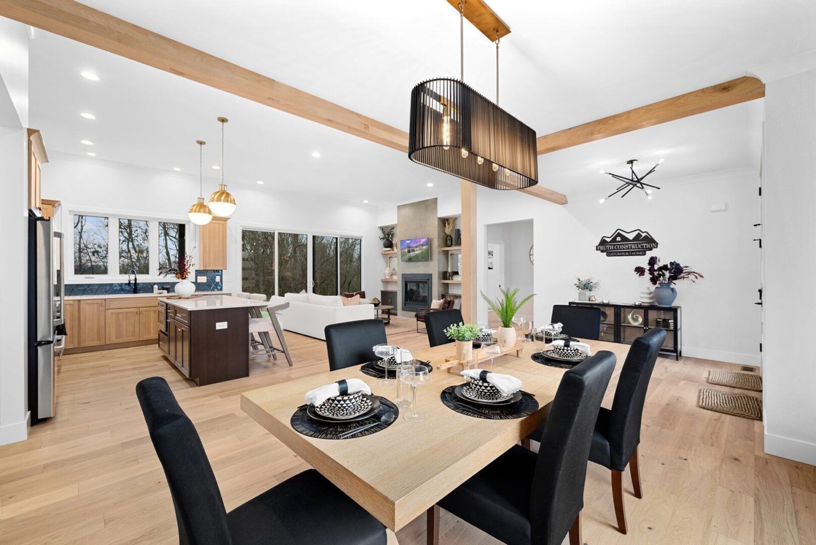 Dine in a room adorned with modern lighting, white oak beams, and engineered hardwood floors.