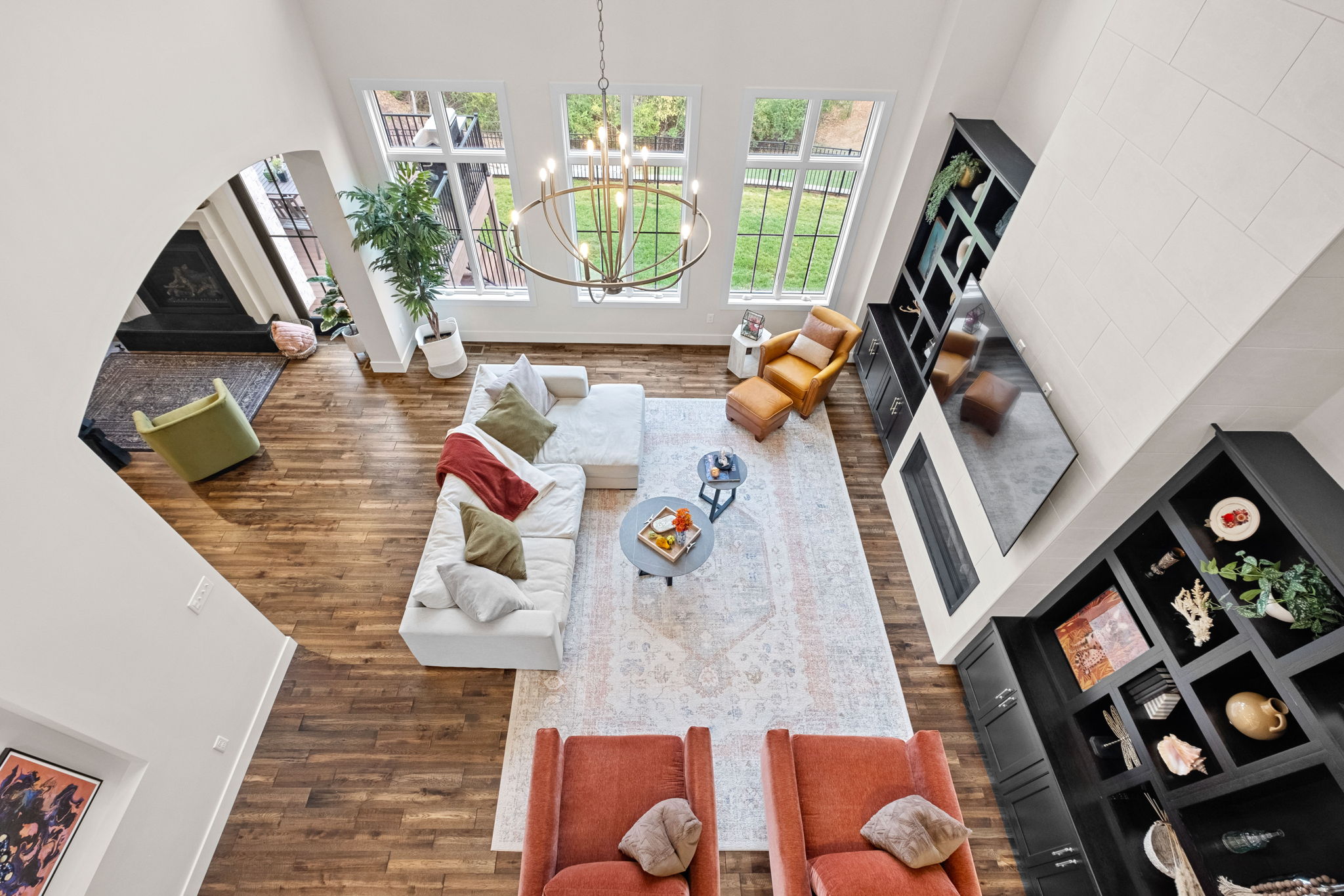 A great room featuring a tiled fireplace, 14-foot ceilings, and a two-story design.