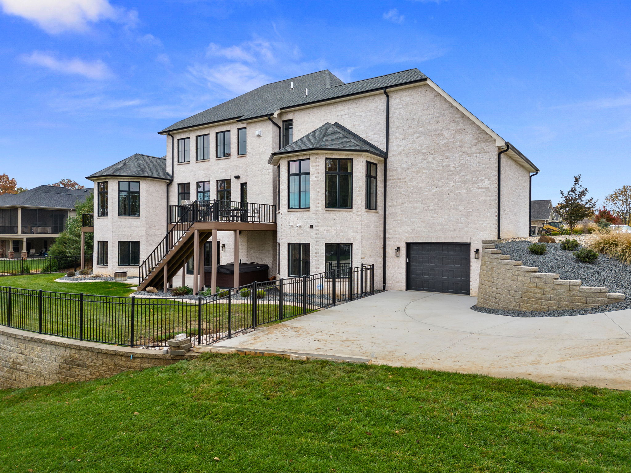 The home features a rear view of the European style, complete with stone and EIFS. It boasts large back decks accessible from the kitchen and a private deck adjoining the primary bedroom suite.