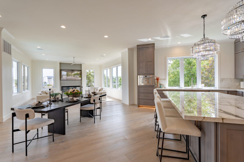 Dining room table overlooks the sunroom sitting area with a 180-degree lake view.