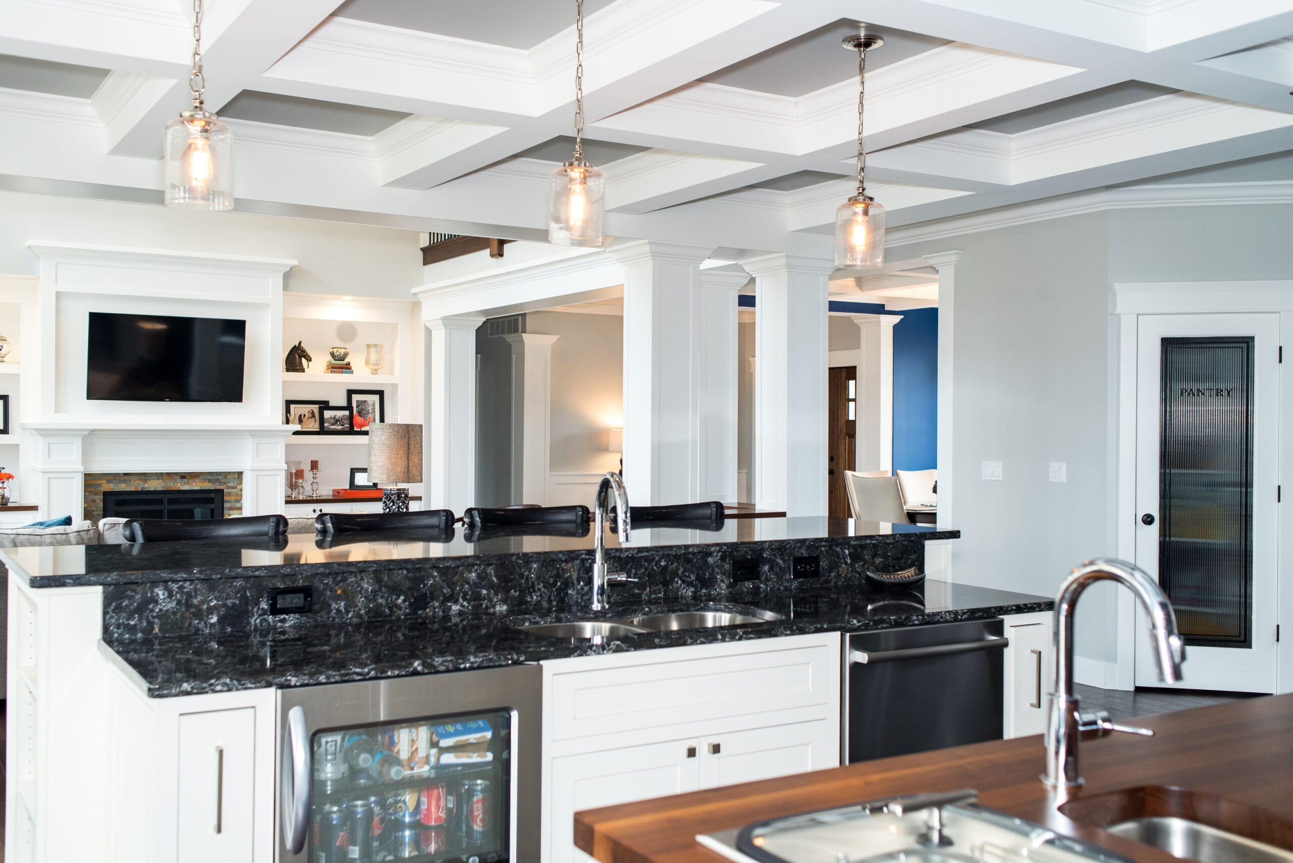 A Craftsman-style kitchen featuring luxurious, dark-stained custom cabinets and coffered ceiling.