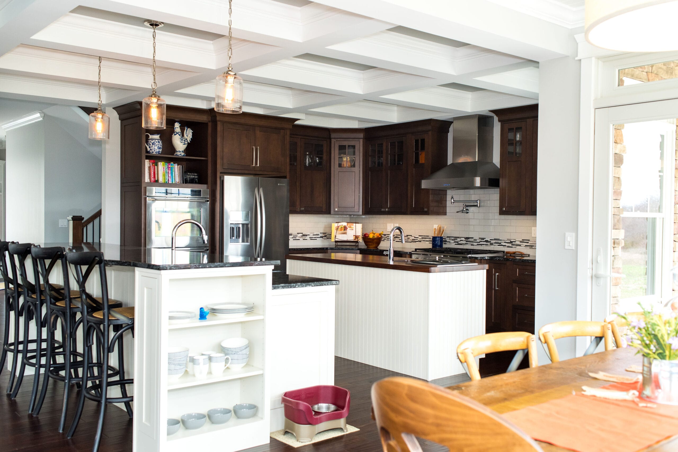 A Craftsman-style kitchen featuring luxurious, dark-stained custom cabinets and coffered ceiling.