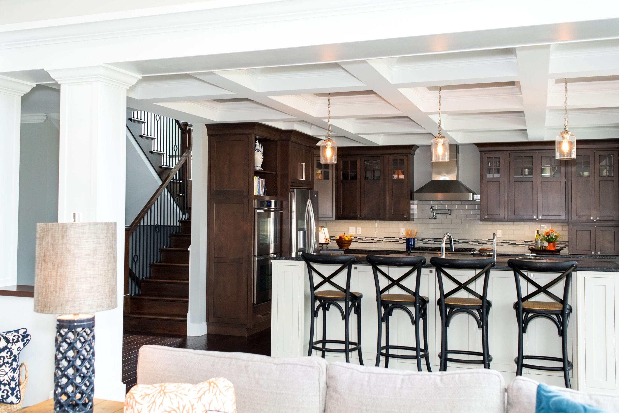 A Craftsman-style kitchen featuring luxurious, dark-stained custom cabinets and coffered ceiling.