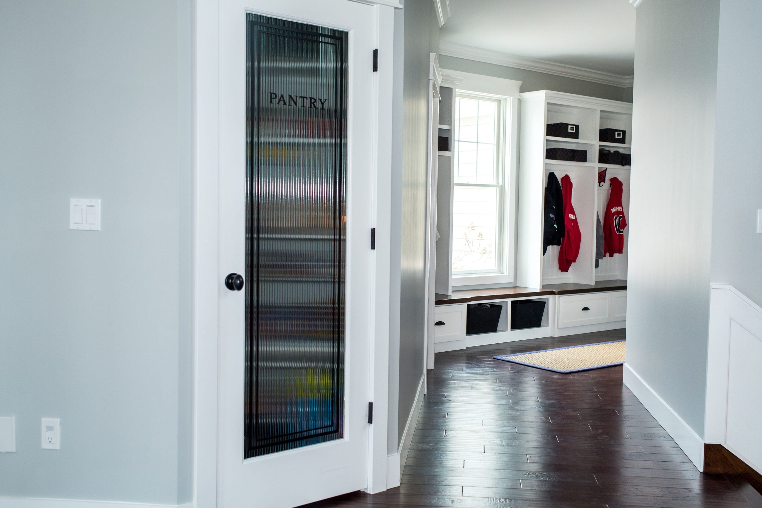 Drop zone custom cubbies and glass pantry door.