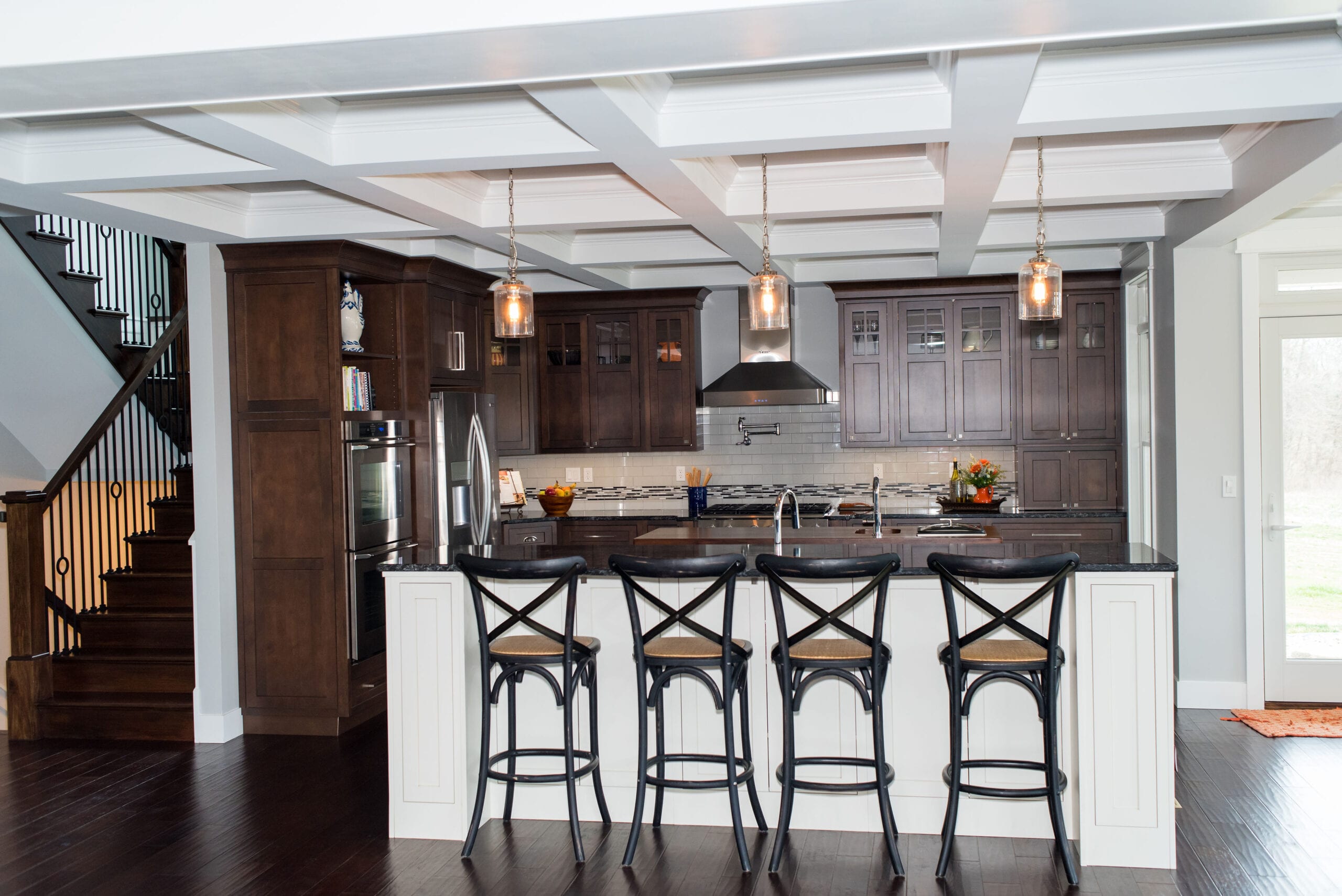 A Craftsman-style kitchen featuring luxurious, dark-stained custom cabinets and coffered ceiling.