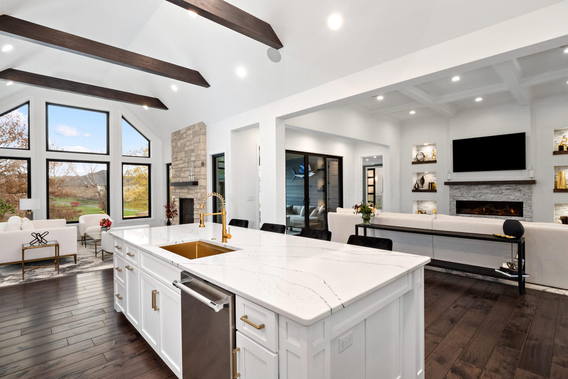 A contemporary modern open floor plan featuring a hearth room, kitchen, and an expansive great room.