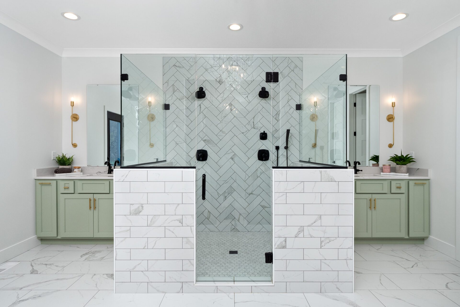 A primary bathroom featuring a spacious walk-in shower, dual shower heads and individual vanities.